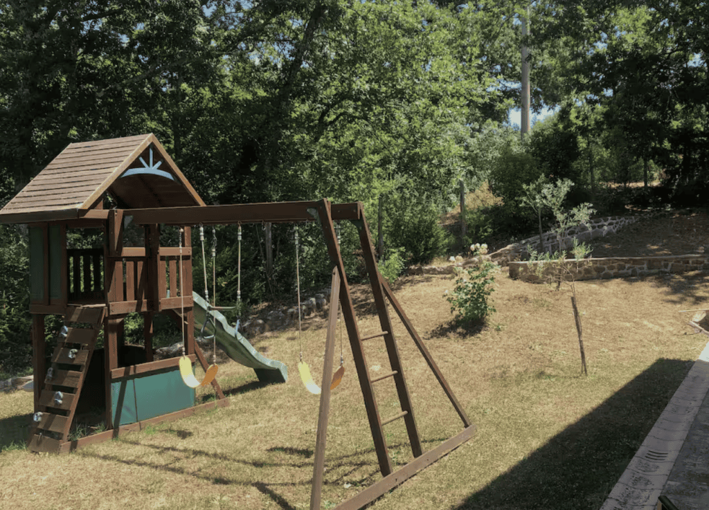 Children’s play area in the secure fenced garden at Villa Tegolaio, ideal for families with young children.