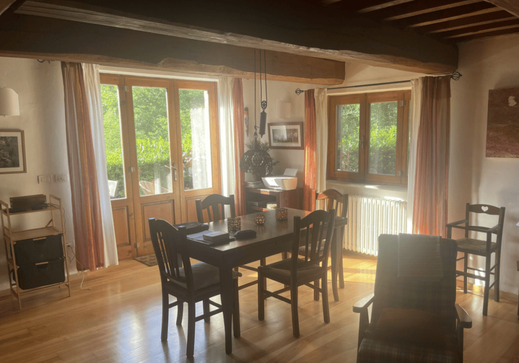 Dining area inside Villa Tegolaio in Umbria with large wooden table and seating for guests.