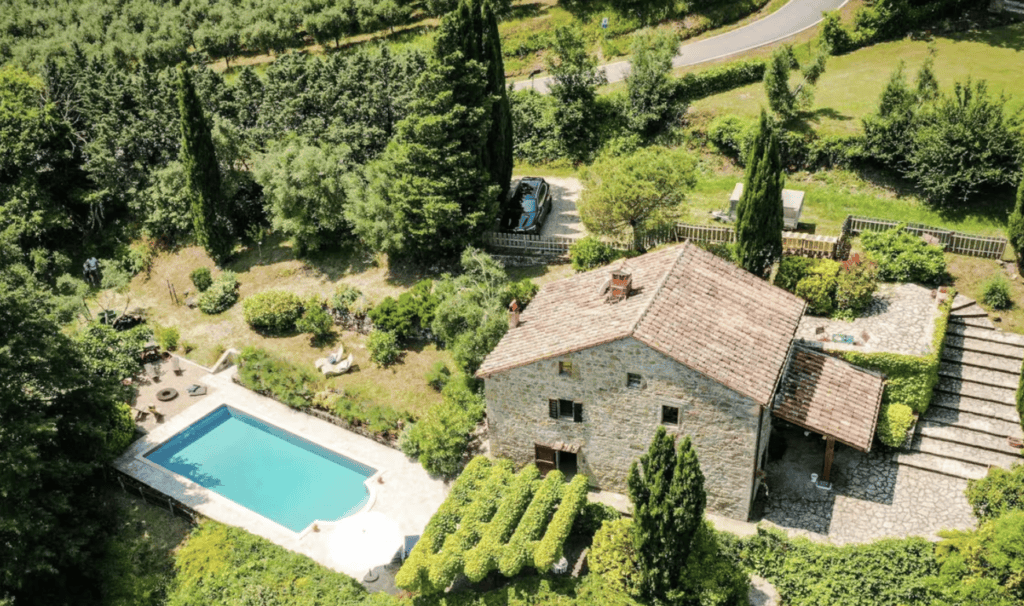 Aerial view of Casa Isabella in Umbria, showing the stone villa, private swimming pool, landscaped gardens and surrounding countryside.