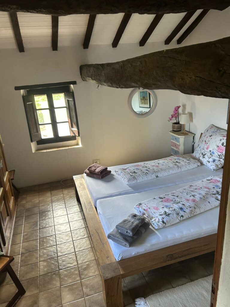 Comfortable double bedroom at Casa Isabella featuring European-style twin mattresses arranged as a double bed and traditional furnishings.